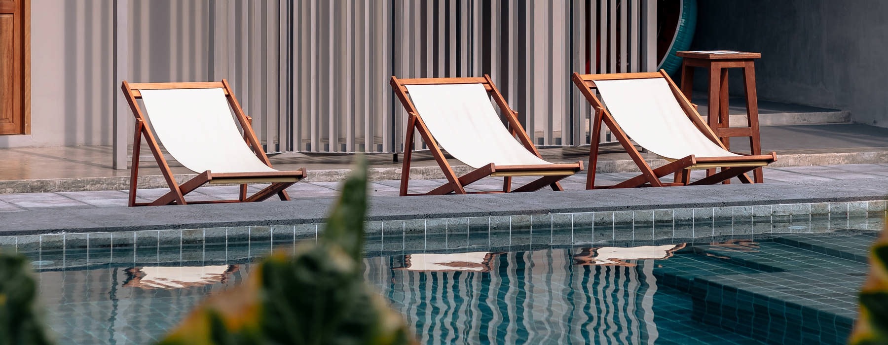 lounge chairs at swimming pool's ledge