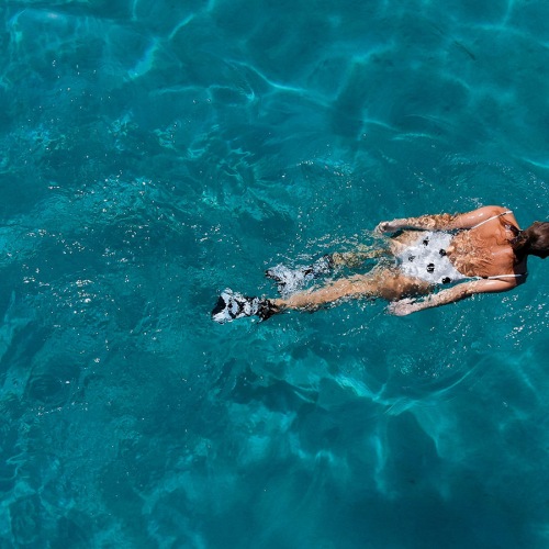 Large sparkling blue pool with a large pool deck and lounge chairs