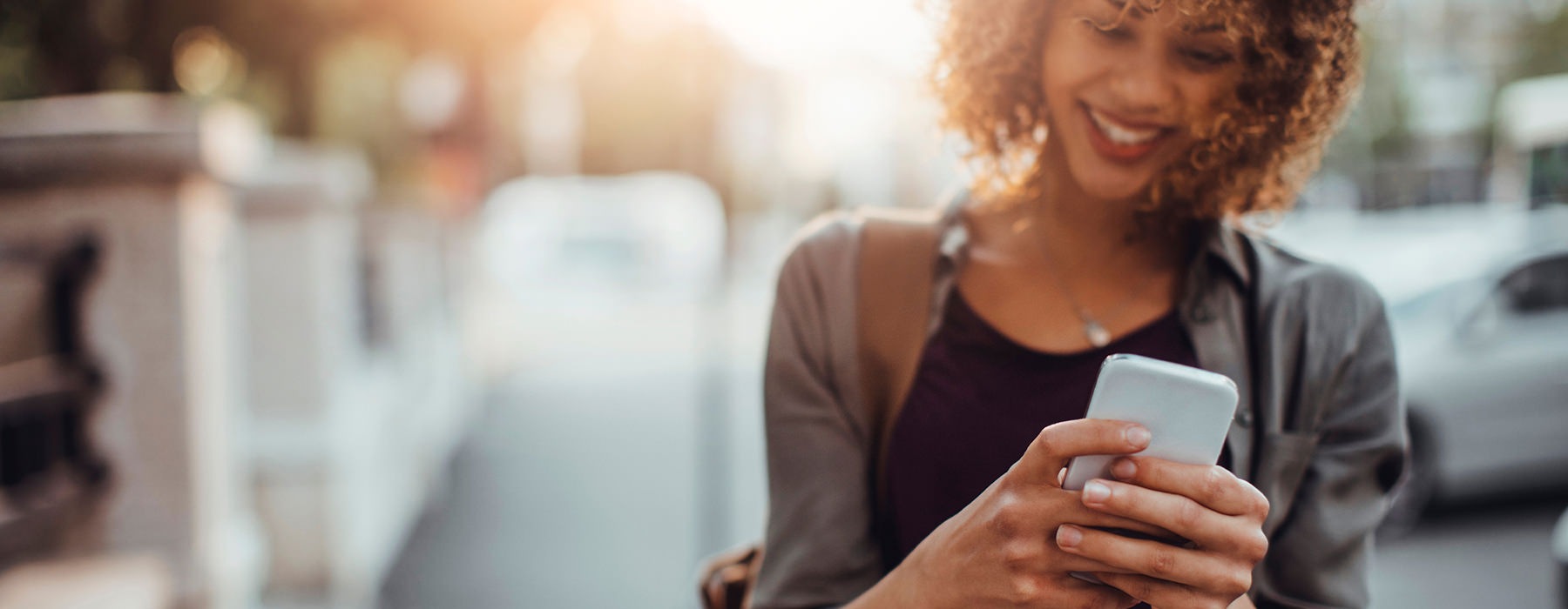 Woman walking down the street looking at her phone 